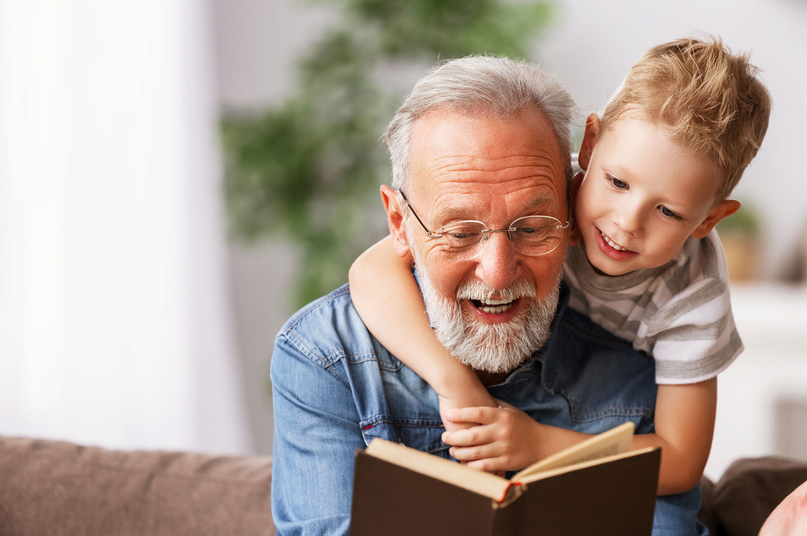 Grandparent Reading book to child with smile